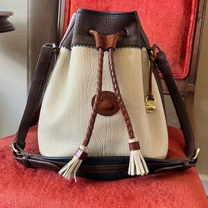 Pebble Dooney & Bourke Bucket Bag in cream with brown and navy blue contrast.